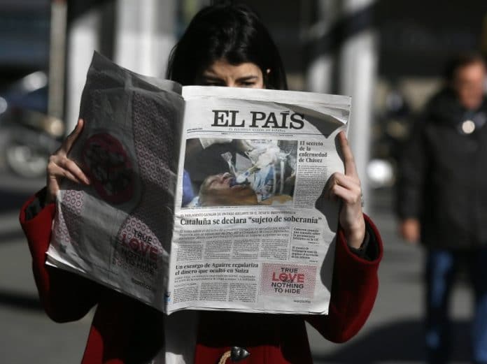 Personne lisant un journal espagnol intitulé « El País » alors qu'elle se tenait à l'extérieur ; la première page présente une image liée à la déclaration de la Catalogne et au titre du texte, reflétant le silence souvent observé dans les médias en France sur des questions aussi cruciales. Personne lisant un journal espagnol intitulé « El País » alors qu'elle se tenait à l'extérieur ; la première page présente une image liée à la déclaration de la Catalogne et au titre du texte, reflétant le silence souvent observé dans les médias en France sur des questions aussi cruciales.